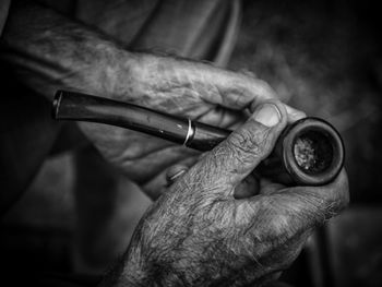 Cropped hands of man holding smoking pipe