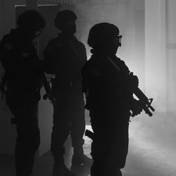 Silhouette people standing against wall