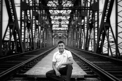 Portrait of man sitting on railroad track