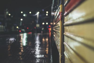 Wet illuminated railroad station platform at night