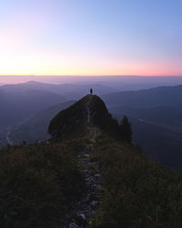 Scenic view of mountain with silhouette man against sky during sunset