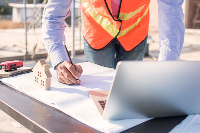 Midsection of man working on table