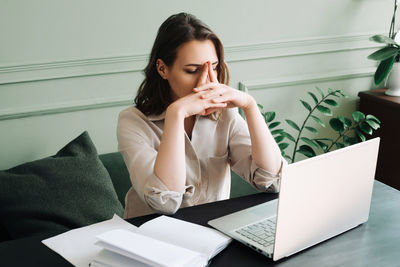 Young woman using laptop at home