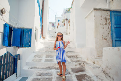 Portrait of young woman standing against wall