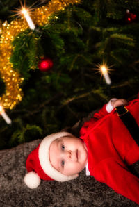 Portrait of cute girl lying on christmas tree