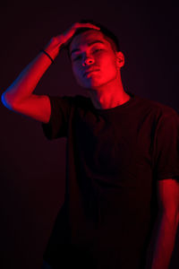 Portrait of young man against black background