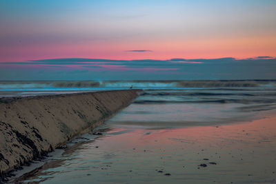 Scenic view of beach against sky during sunset