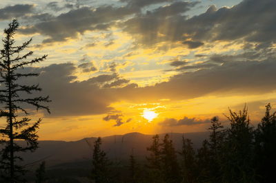 Scenic view of silhouette mountains against orange sky