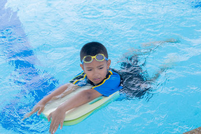 High angle view portrait of boy swimming in pool