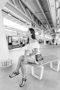 Full length of woman sitting on bench