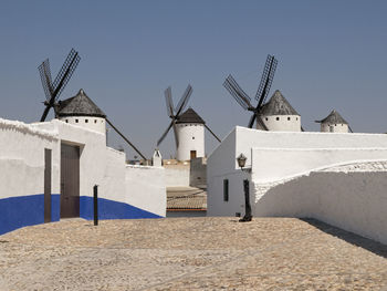 Traditional windmill by building against clear sky