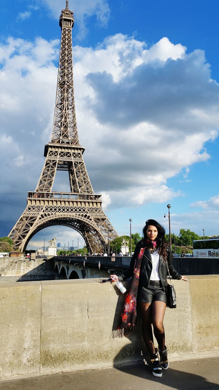 lifestyles, leisure activity, casual clothing, sky, built structure, full length, architecture, person, young adult, standing, cloud - sky, day, travel, young women, looking at camera, portrait, outdoors