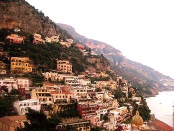 Townscape by mountains against clear sky