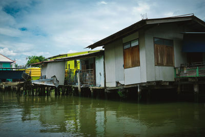 Houses by canal against sky