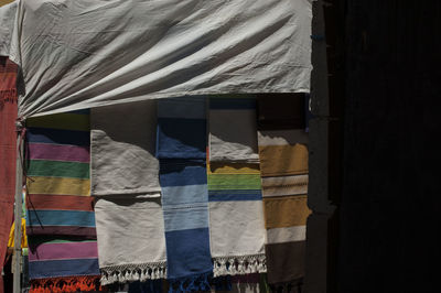 Close-up of multi colored umbrellas hanging on bed by window