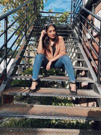 Portrait of young woman sitting on staircase