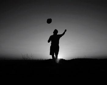 Silhouette children playing on field against clear sky