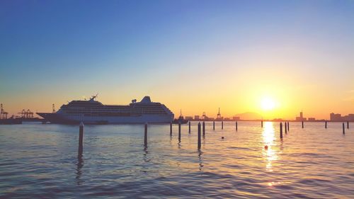 Cruise ship on sea against sky during sunrise