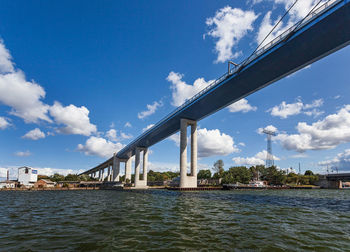 Bridge over river against sky in city