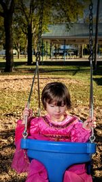 Close-up of girl on swing at playground