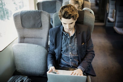 Businessman using laptop in train
