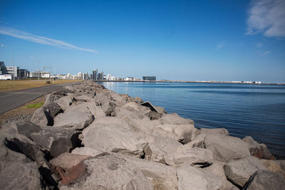 Rough stones on the harbour of reykjavík, iceland. road adjoining.