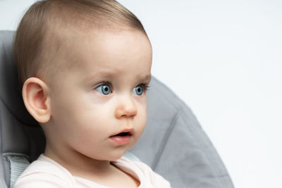 Close-up portrait of cute baby boy against white background