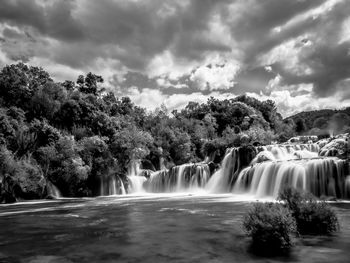 Scenic view of waterfall against sky
