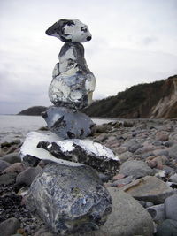 Stack of stones on rock against sky