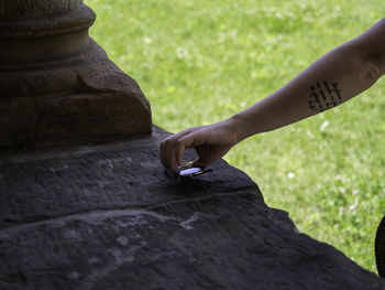 Cropped hand of woman keeping sunglasses on retaining wall