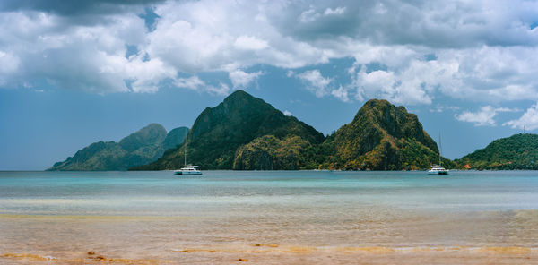 Scenic view of sea and mountains against sky