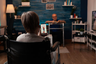 Rear view of people sitting on table