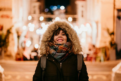 Portrait of smiling young woman in winter at night