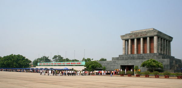 People in front of historical building against clear sky