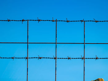 Low angle view of barbed wire against clear sky