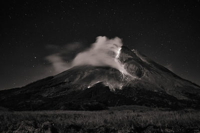 Scenic view of snowcapped mountain against sky at night