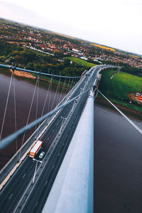 Aerial view of suspension bridge over river against sky