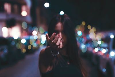 Close-up of woman hand with illuminated lights at night