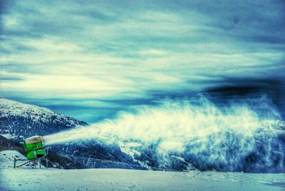 Scenic view of snow covered mountains against blue sky