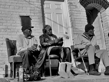 People sitting on chair against buildings