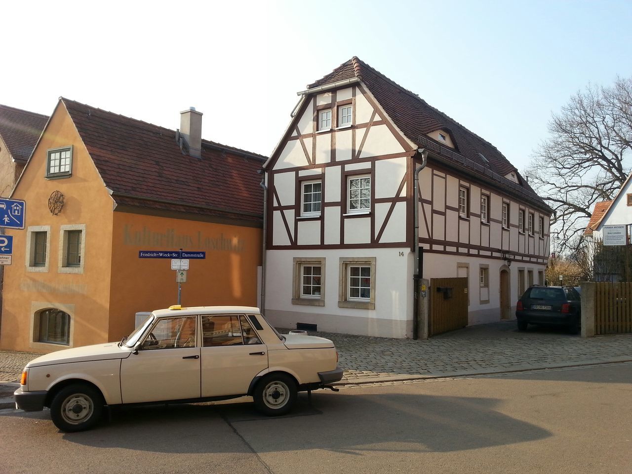 building exterior, architecture, built structure, transportation, land vehicle, car, street, mode of transport, road, parking, parked, stationary, clear sky, house, bicycle, residential structure, residential building, city, day, sunlight