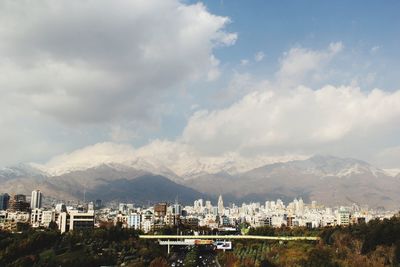 Buildings in city against cloudy sky