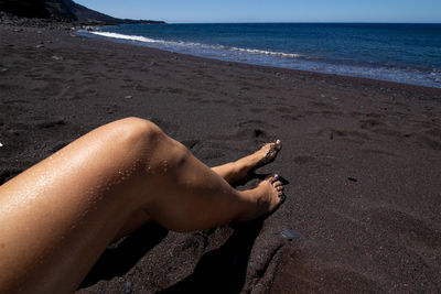 Low section of woman relaxing on beach