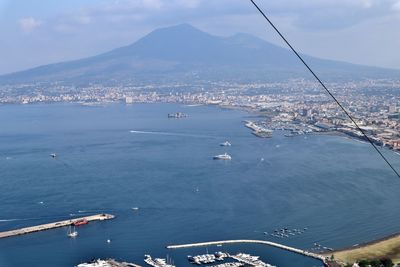 High angle view of sea by cityscape against sky