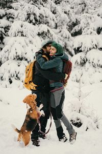 High angle view of a couple and a dog on snow during winter