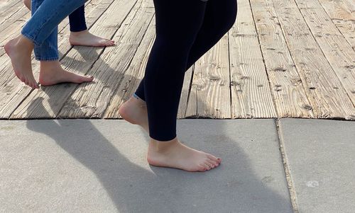 Low section of women walking on footpath