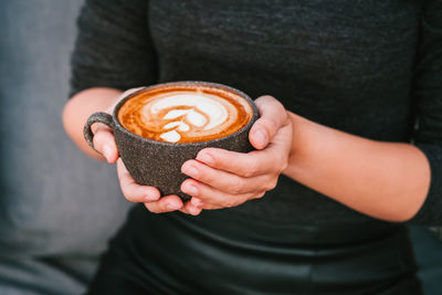 Close up photo of coffee in a grey ceramic cup.