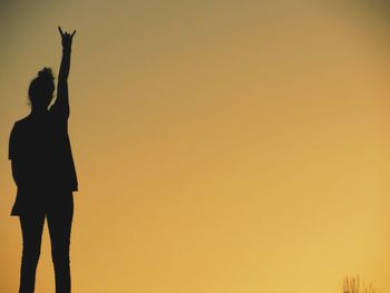 Silhouette woman standing against clear sky during sunset