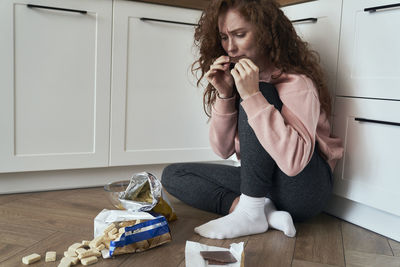 Young woman sitting on sofa at home