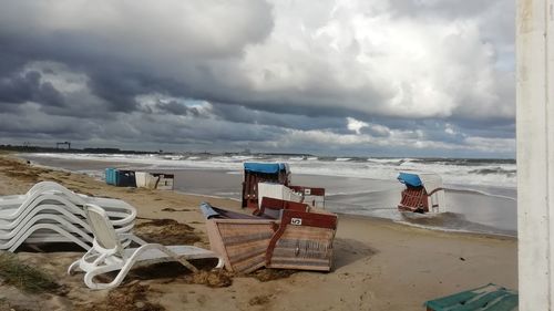 Chairs on beach against sky